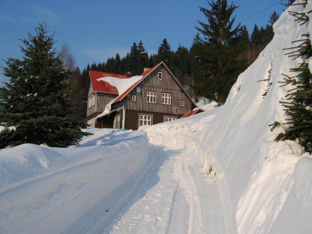 ein Haus ist vor der Tür mit Schnee bedeckt in der Unterkunft Apartmán 3 Špindlerův Mlýn in Špindlerův Mlýn