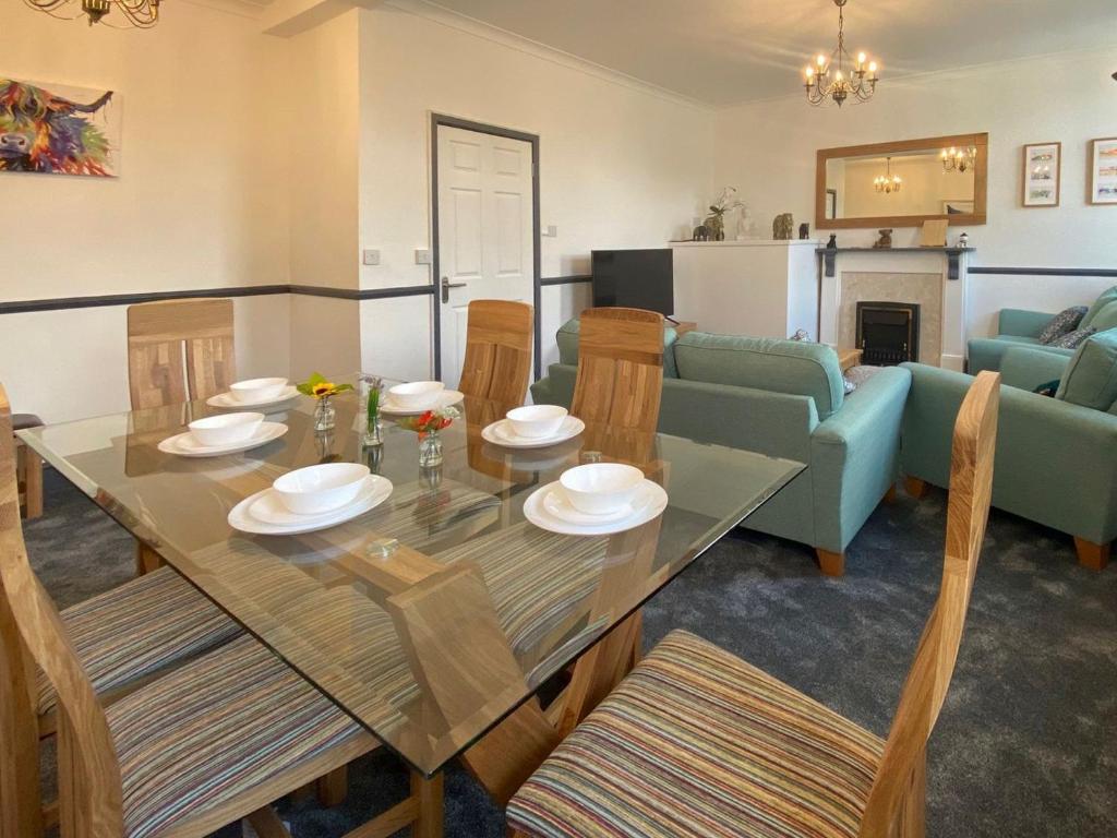 a dining room and living room with a table and chairs at The Oak Apartment in Brigham