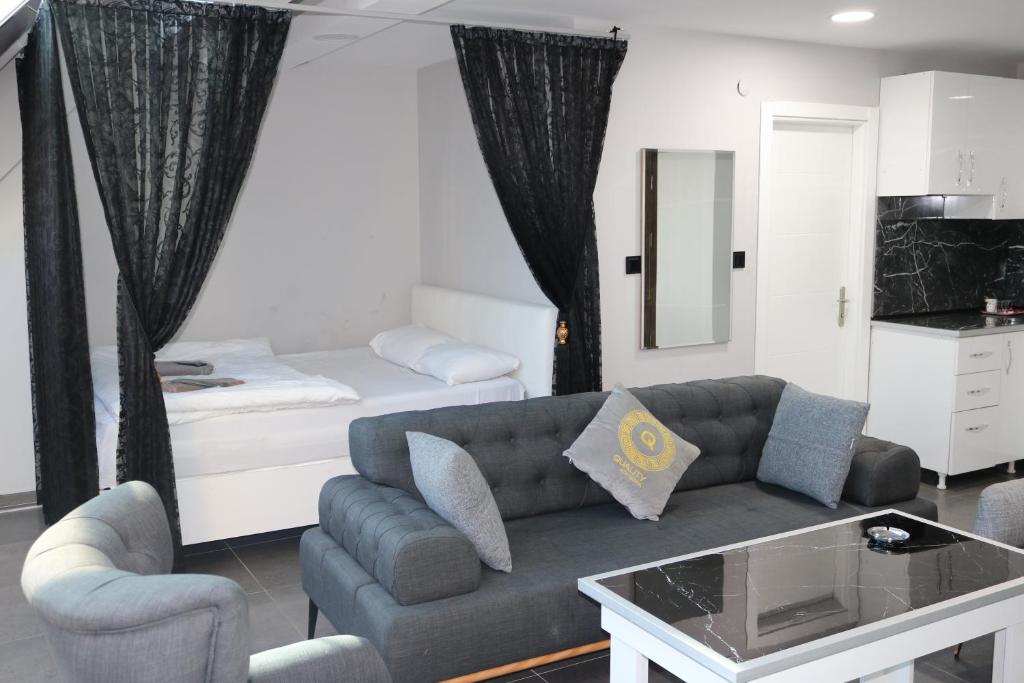 - un salon avec un canapé et un lit dans l'établissement Carpe Diem Suit, à Kırac