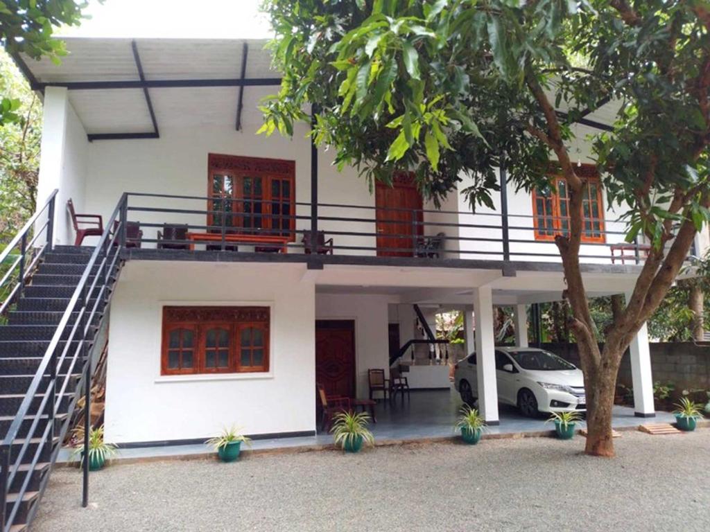 une maison avec un balcon et une voiture garée devant dans l'établissement Lion Home Stay Anuradhapura, à Anurâdhapura
