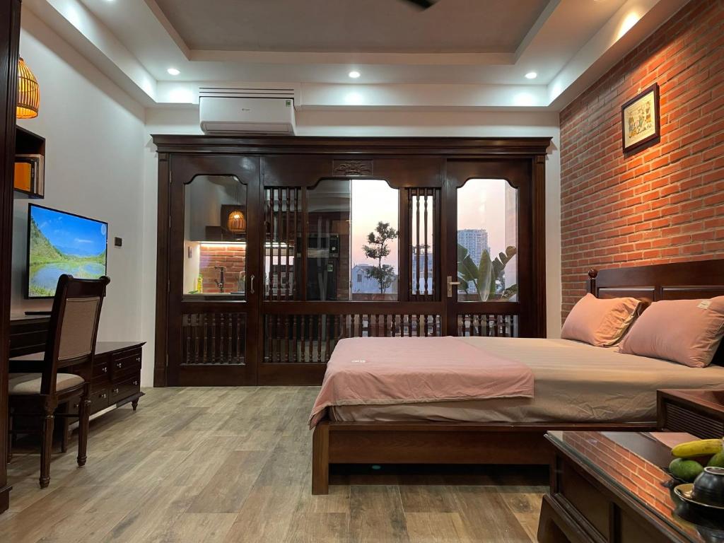 Schlafzimmer mit einem Bett, einem Schreibtisch und einem Fenster in der Unterkunft Eco nest in Hanoi