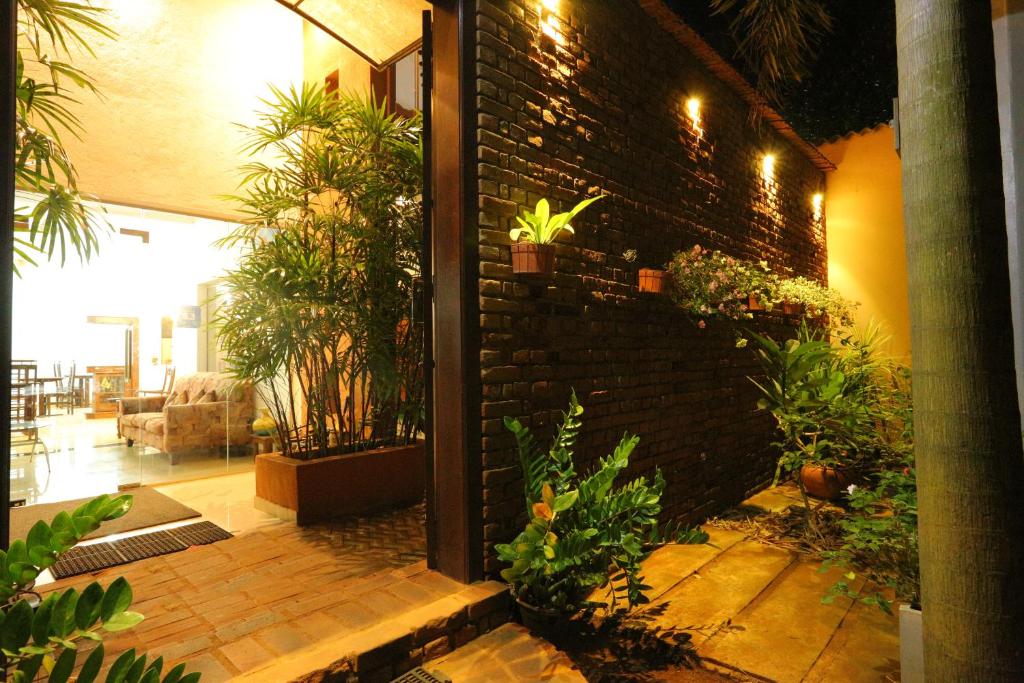 eine Terrasse mit Pflanzen und Ziegelwand in der Unterkunft Hotel Savonrich in Anuradhapura