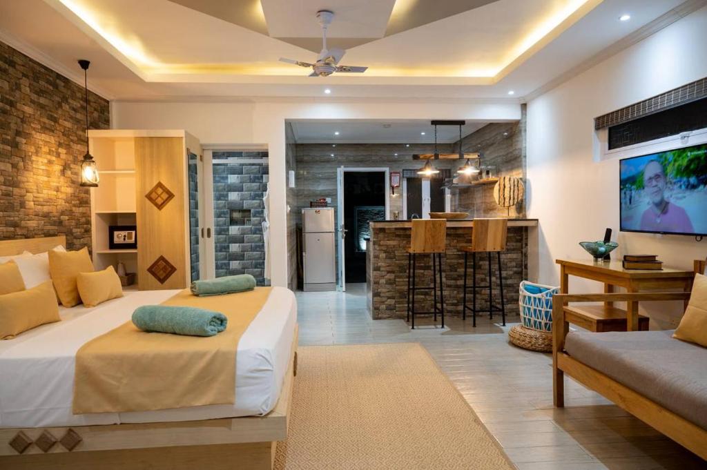 ein Schlafzimmer mit einem Bett und eine Küche mit einer Bar in der Unterkunft Treasure Villa in Praslin
