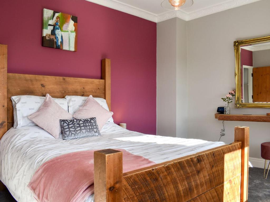 a bedroom with a wooden bed with purple walls at Dark Lane in Chesterfield