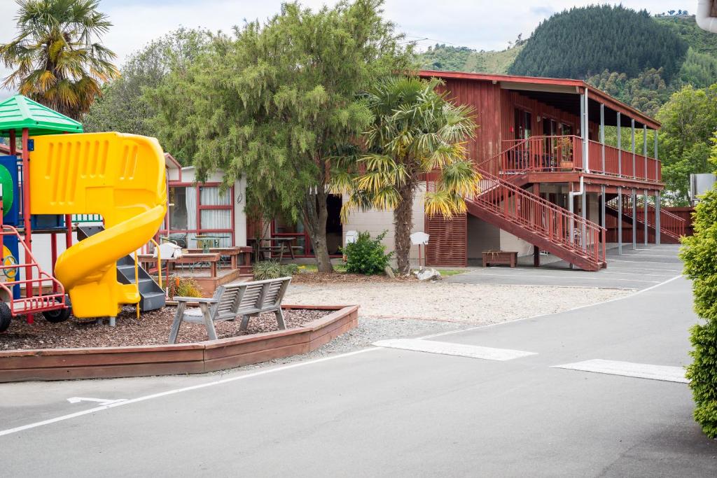 um parque infantil com escorrega e um edifício em Nelson City TOP 10 Holiday Park em Nelson