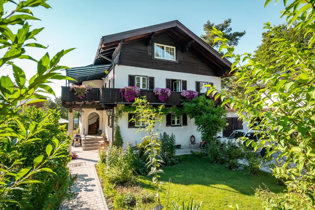 ein Haus mit einem Balkon mit lila Blumen darauf in der Unterkunft Ferienwohnung Zur Wache in Samerberg
