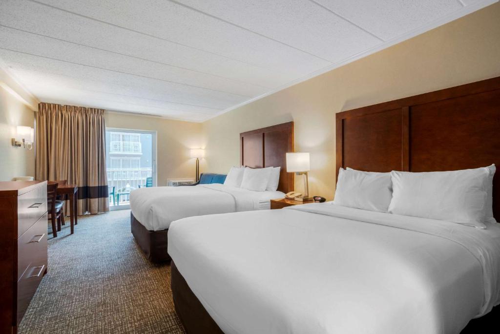 a hotel room with two beds and a desk at Comfort Inn Ocean City Boardwalk in Ocean City