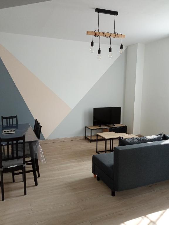 ein Wohnzimmer mit einem Sofa und einem Tisch in der Unterkunft Joli appartement moderne / proche de Dinard in Pleurtuit