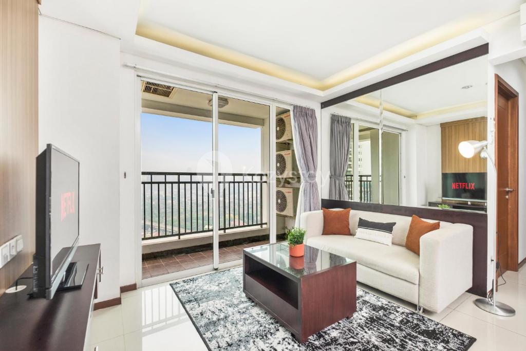 a living room with a couch and a tv at Gala by Kozystay - Thamrin in Jakarta