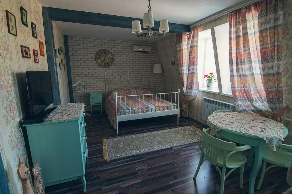 a bedroom with a bed and a table and chairs at Dragomir Apartments in Cherkasy