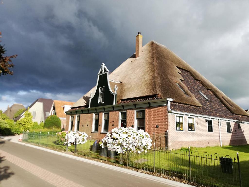 una gran casa de ladrillo con techo de paja en B&B Suyder Cogge, en Hem