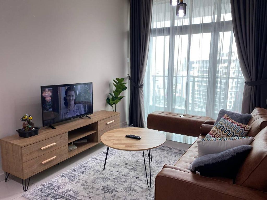 een woonkamer met een bank, een tv en een tafel bij Legasi Kampung Baru KL Homestay in Kuala Lumpur