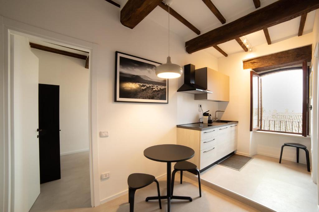 een keuken met een tafel en stoelen in een kamer bij Appartamento centro storico Gubbio in Gubbio