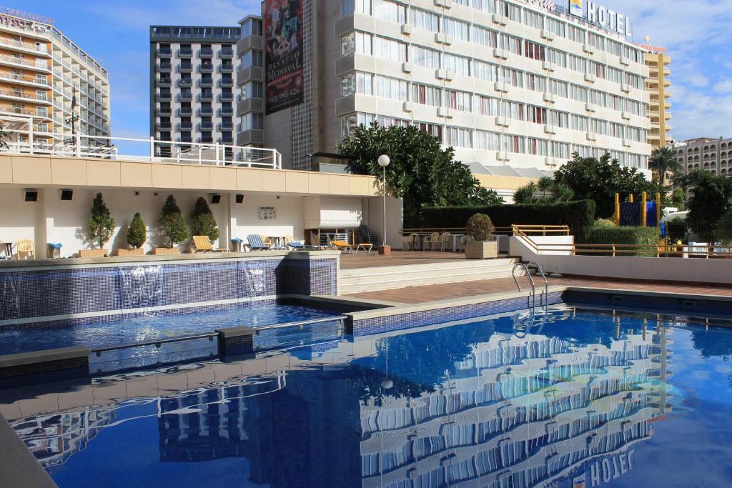 a swimming pool in front of a building at Apartamentos Viña del Mar in Benidorm