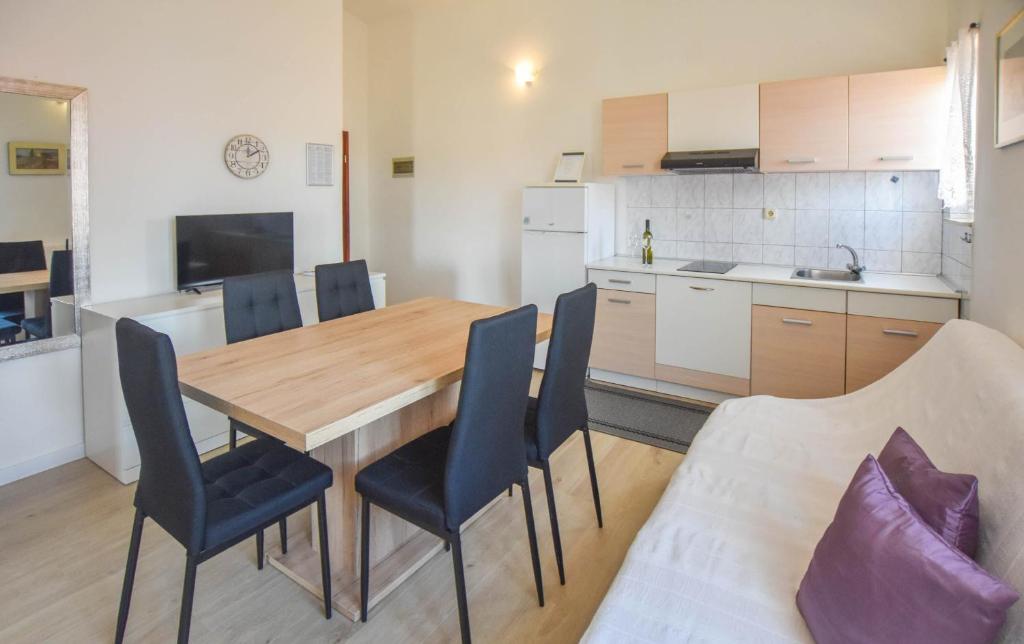 kuchnia i jadalnia z drewnianym stołem i krzesłami w obiekcie Apartments Anchor w mieście Pašman