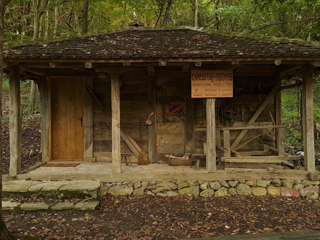 a small wooden building with a sign on it at Brvnara u planini in Petrovac na Mlavi