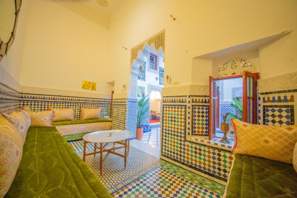 uma sala de estar com um sofá e uma mesa em Riad Rayhana em Fez