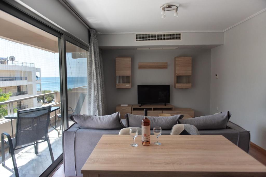- un salon avec un canapé et une table avec des verres à vin dans l'établissement Sea view apartment in Alimos region (D4), à Athènes