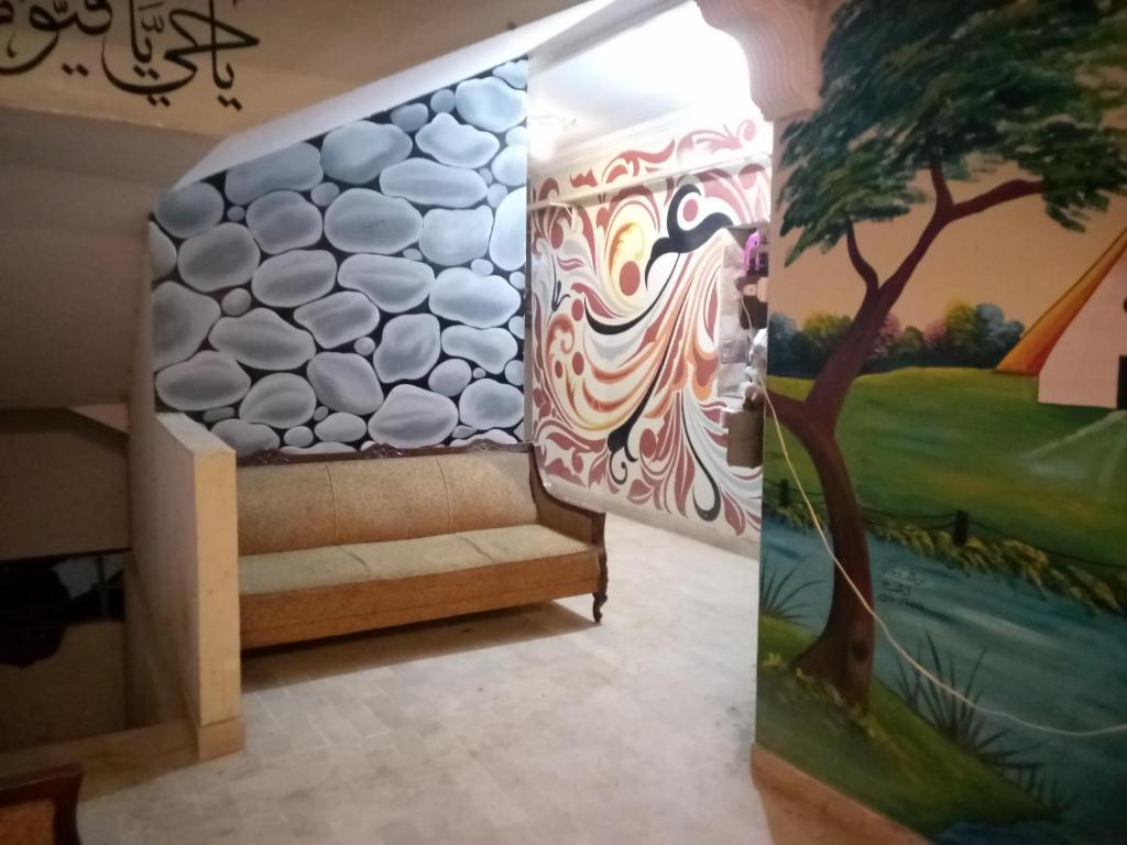 a room with a wall with a painting and a bench at Entire Furnished Two bedrooms Apartment Ground Floor with kitchen in Karachi
