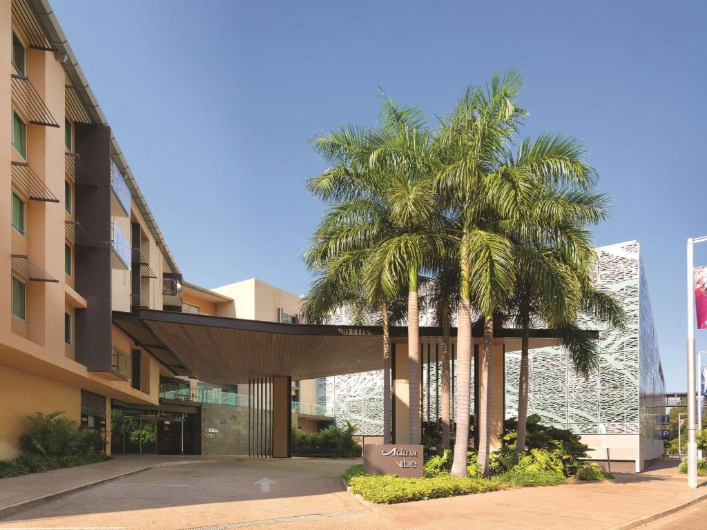 un grupo de palmeras frente a un edificio en Vibe Hotel Darwin Waterfront, en Darwin
