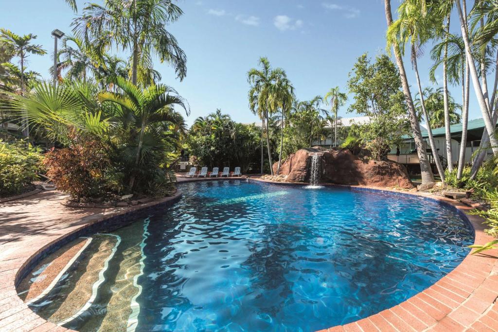 a swimming pool with a waterfall in a resort at Travelodge Resort Darwin in Darwin