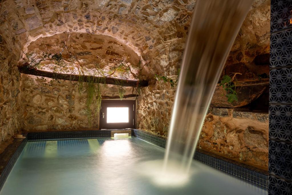 WUNDERGARTEN Private Home Spa في Gratteri: مسبح في مبنى حجري مع نافذة