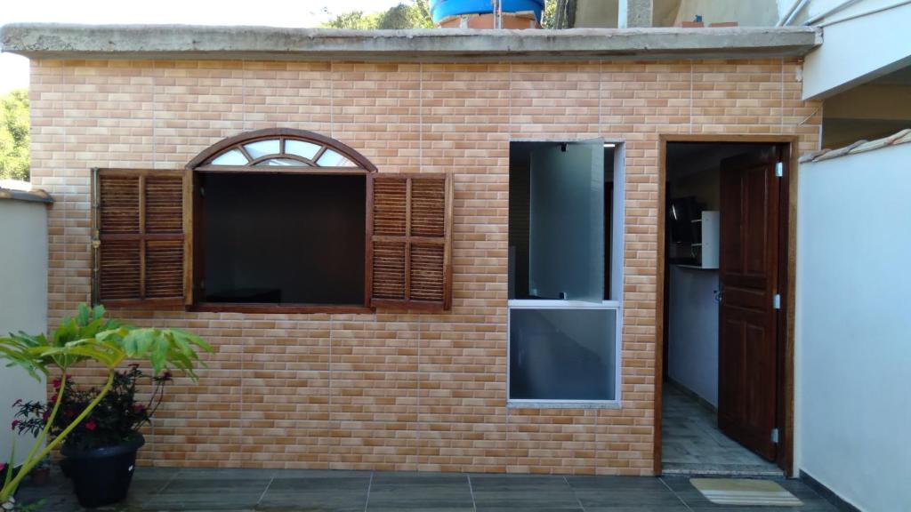 ein Backsteinhaus mit einer Tür und einem Fenster in der Unterkunft hospedagem recanto do sábia 3 in Caparaó Velho
