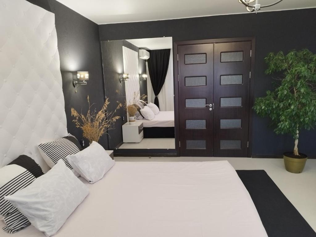ein Schlafzimmer mit 2 Betten und eine Tür mit einer Pflanze in der Unterkunft Sky the Apartment Centre in Tiraspol
