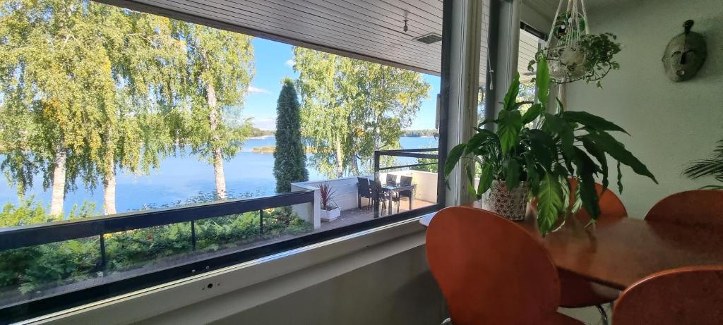 ein Esszimmer mit einem Tisch und einem großen Fenster in der Unterkunft Gorgeous apartment by the sea in Helsinki