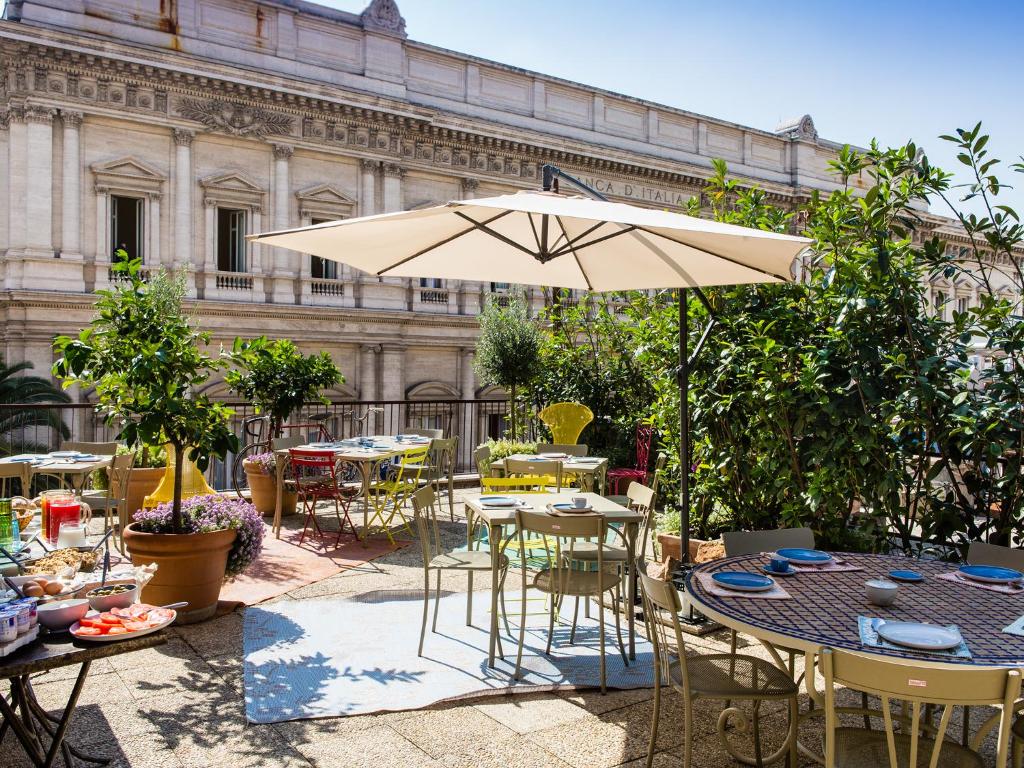 a patio with tables and chairs and an umbrella at Salotto Monti in Rome
