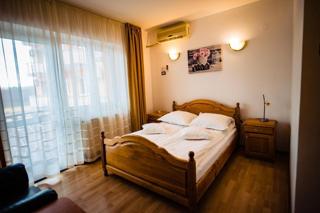 a bedroom with a bed and a large window at Pensiune Roua 2 in Arad