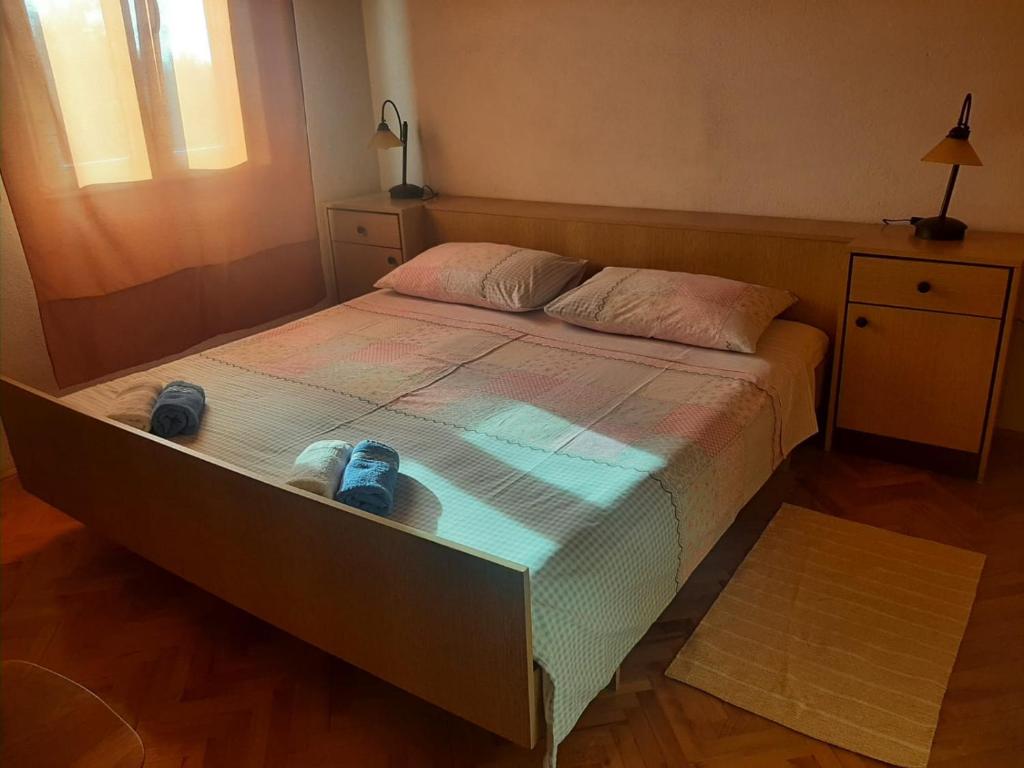 a bedroom with a bed with two shoes on it at Apartmani Ino in Škrip