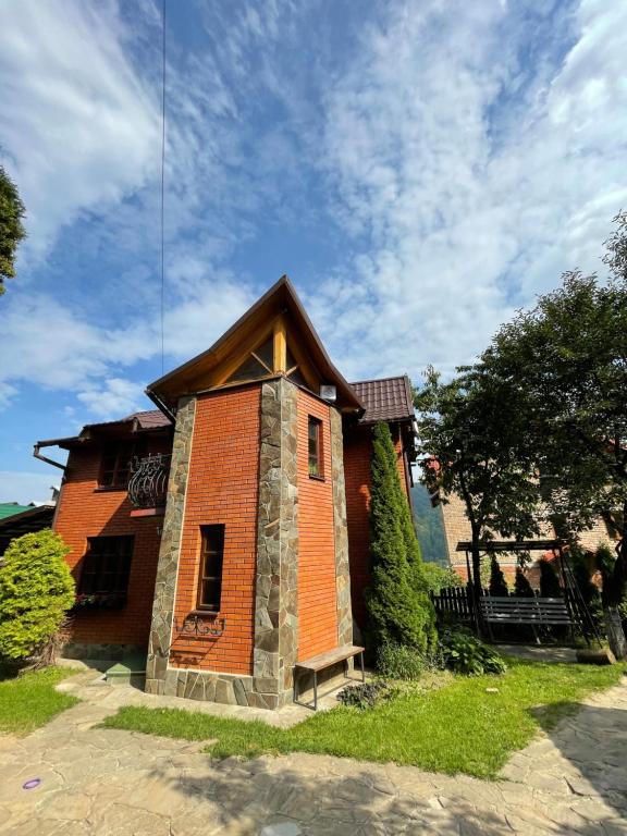 a small brick house with a roof at Girske Povitria Cottage in Yaremche