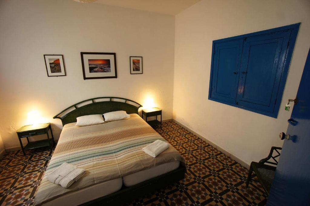 a bedroom with a bed with two tables and a window at Sol y Mar Surf Camp in Corralejo