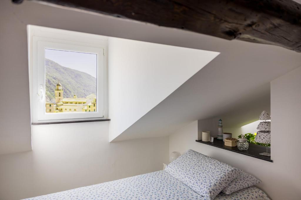 a bedroom with a bed and a window at La mansarda sul Porto in Camogli
