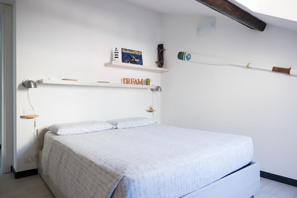 a white bedroom with a white bed in a room at La mansarda sul Porto in Camogli