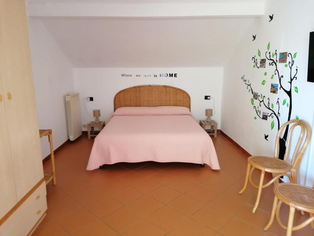 - une chambre avec un lit avec une couverture rose et 2 chaises dans l'établissement Appartamento Pierina - (009001-LT-0668), à Alassio