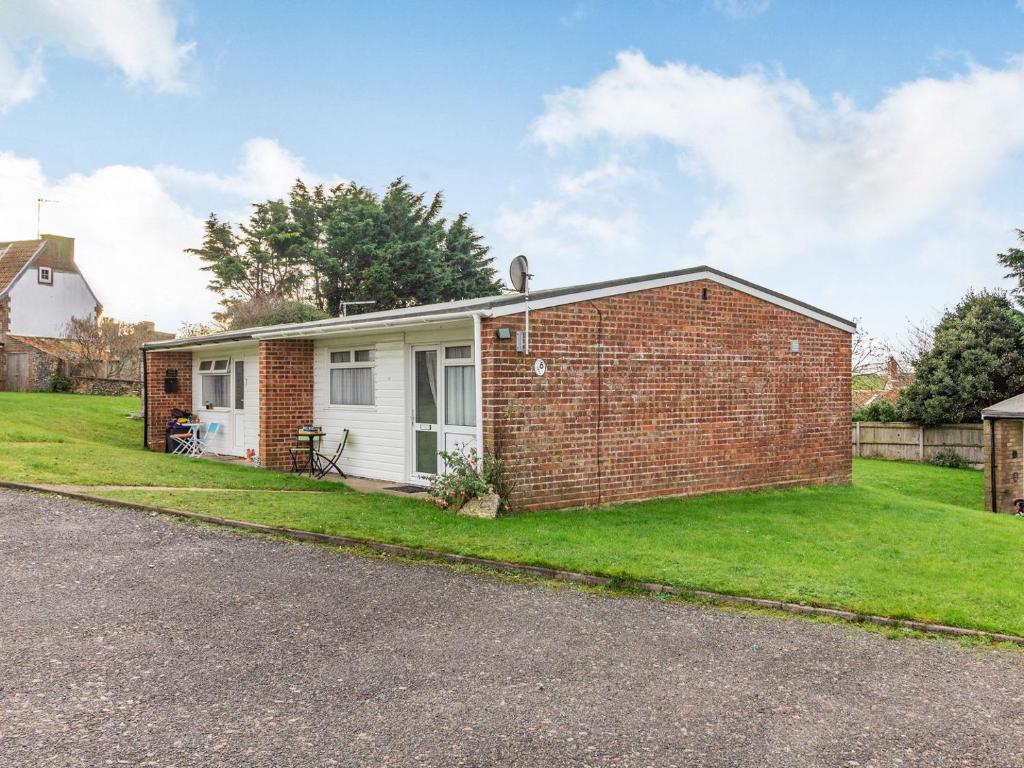 a brick house with a lawn in front of it at The Little House in Kessingland