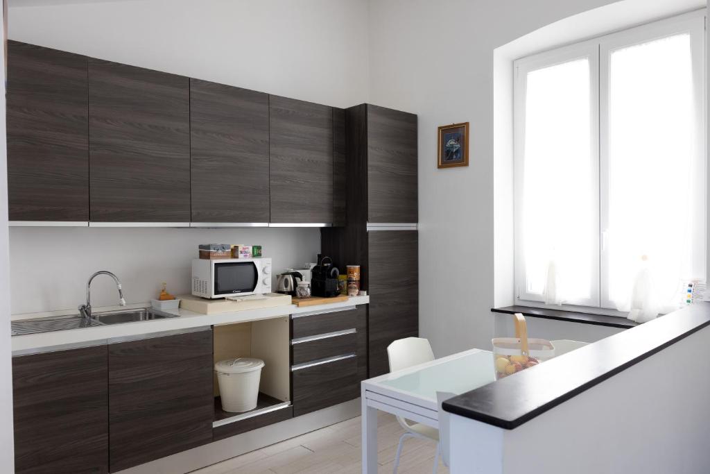 a kitchen with wooden cabinets and a sink and a microwave at La mansarda sul Porto in Camogli