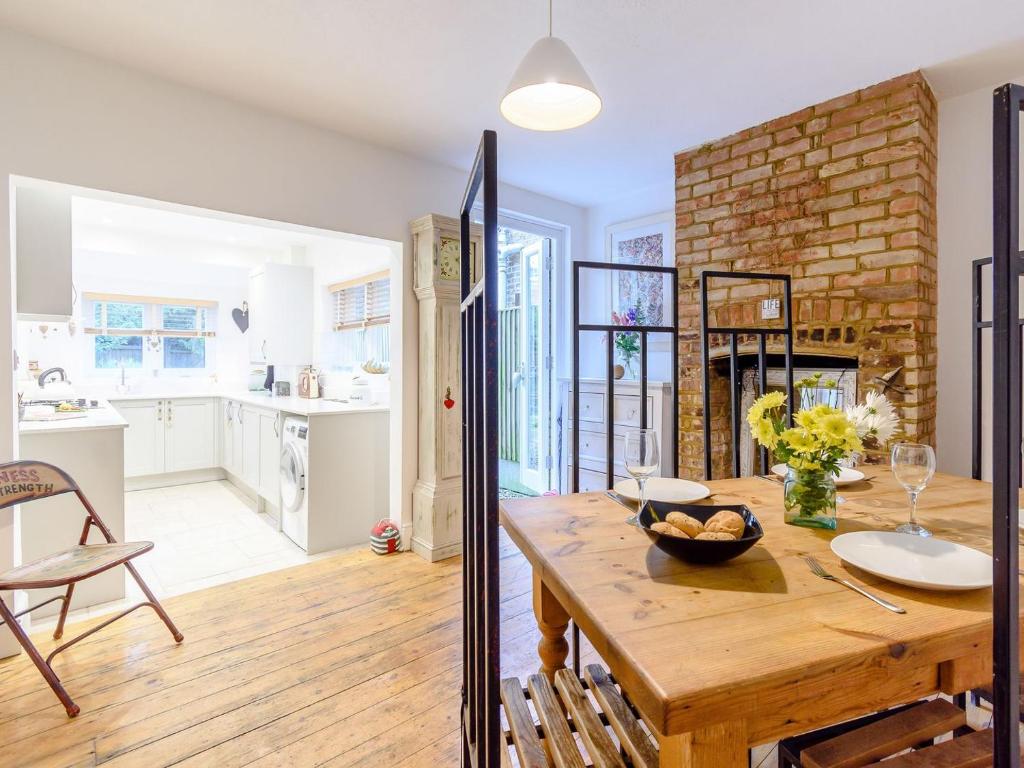 a kitchen and a dining room with a wooden table at Anchor Cottage in Whitstable