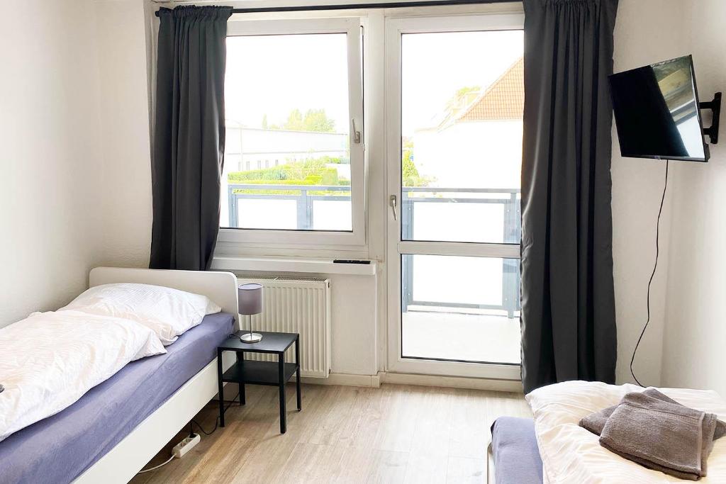 a bedroom with a bed and a window with a tv at Work & Stay Apartment in Bitterfeld