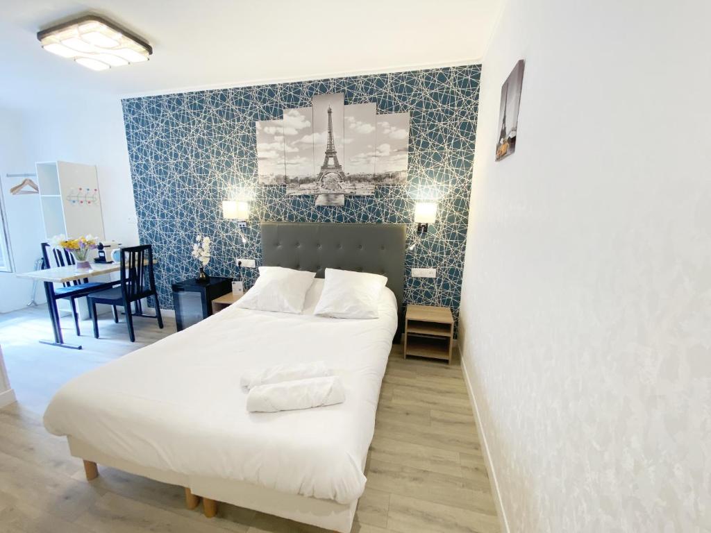 a bedroom with a white bed and a blue wall at Hotel Aviatic in Paris