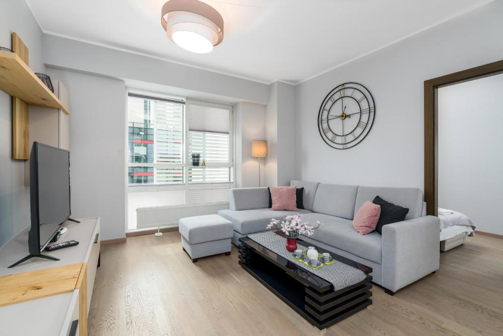 a living room with a couch and a tv at Apartments Poznan Towarowa by Renters in Poznań