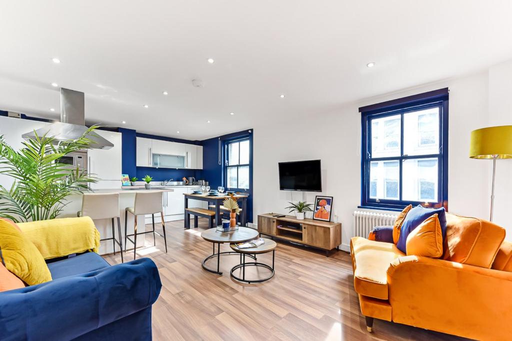 uma sala de estar com dois sofás e uma cozinha em Spacious Cosy 2 Bed Flat, Central London em Londres