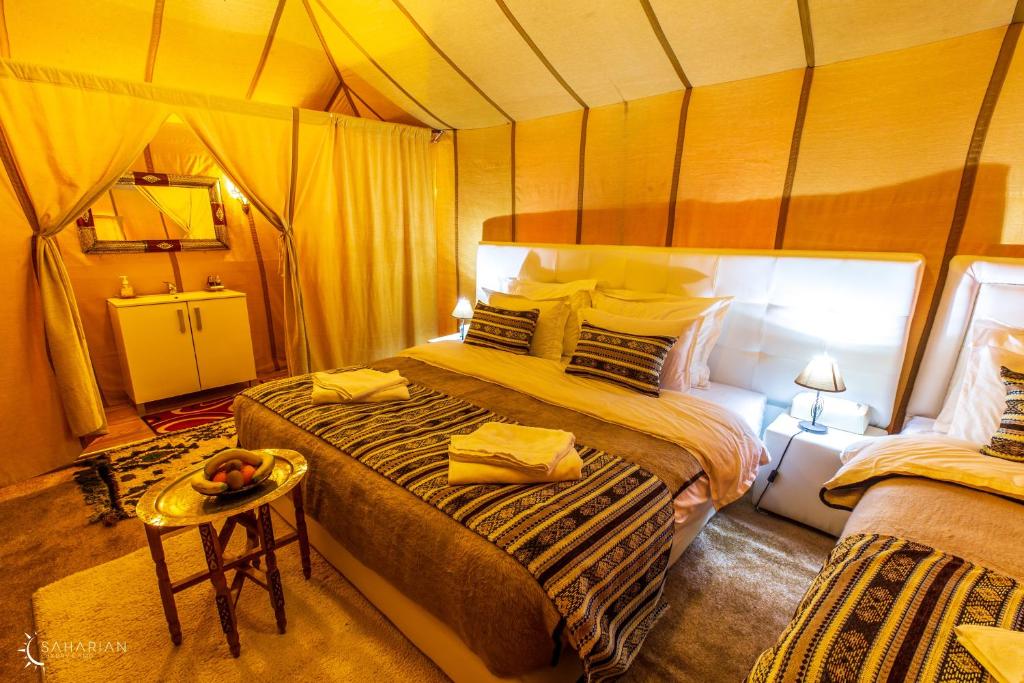 a bedroom with a bed in a tent at Saharian Luxury Camp Deluxe Familly Quadriple in Merzouga