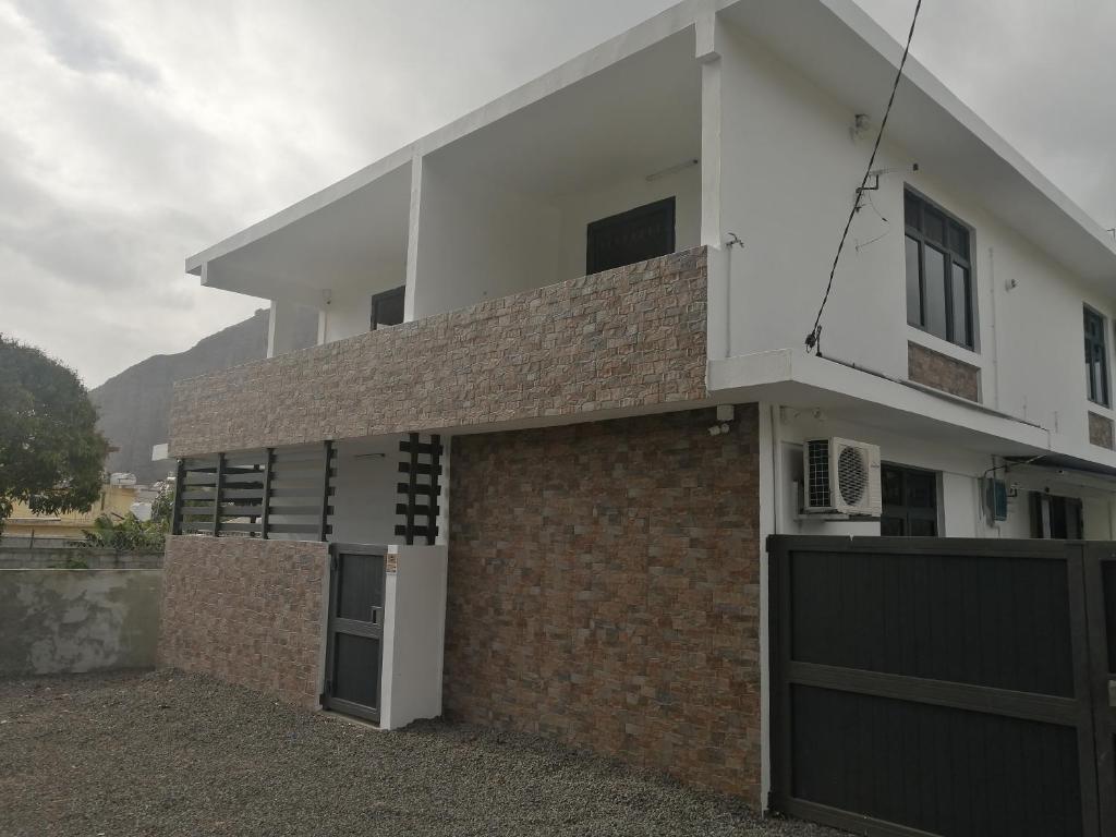 a house with a brick wall and a garage at Hortensia in Quatre Bornes
