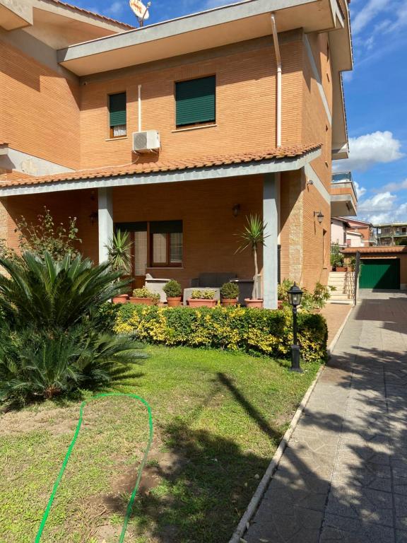 dom z zielonym wężem przed nim w obiekcie Villa Alma w mieście Fiumicino