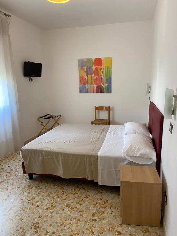 sypialnia z łóżkiem i telewizorem na ścianie w obiekcie Villa Alma w mieście Fiumicino