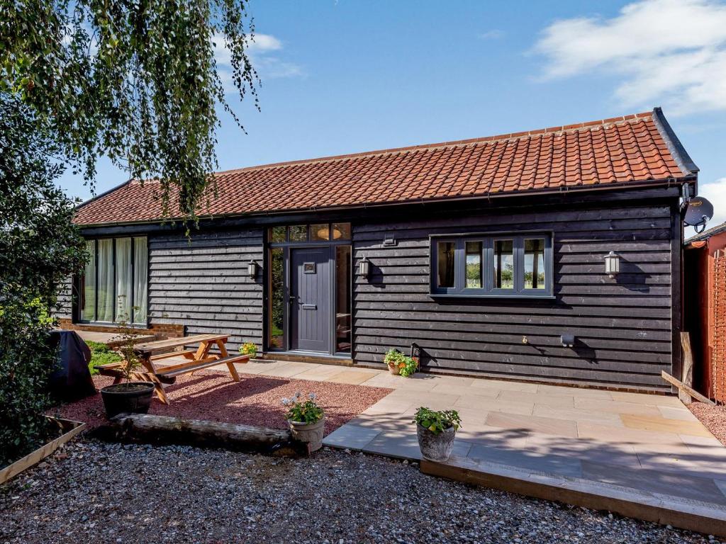 a small house with a picnic table and a bench at Blackwell Barn in Raydon