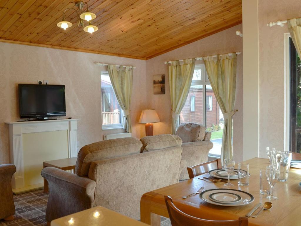a living room with a table and a couch at Lodge A- Uk33088 in Dinnet